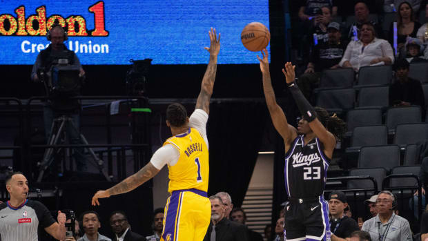 Mar 13, 2024; Sacramento, California, USA; Sacramento Kings guard Keon Ellis (23) takes a three-point shot over Los Angeles Lakers guard D'Angelo Russell (1) during the first quarter at Golden 1 Center. Mandatory Credit: Ed Szczepanski-USA TODAY Sports